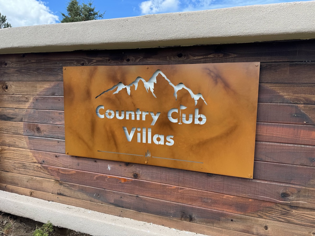 Country Club Villas HOA Community Sign at entrance with mountain backdrop
